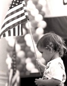Little girl waving an American flag during a political rally.