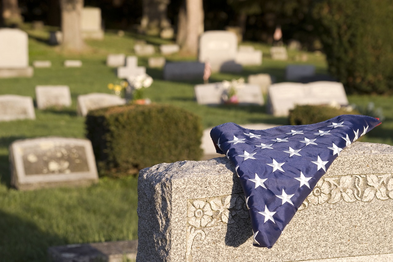 An American flag on a headstone reminds us of the sacrifice and service made by our veterans.