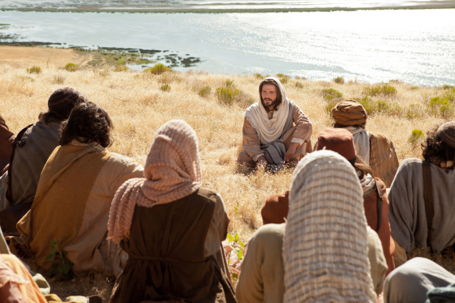 Jesus Christ teaching people the Sermon on the Mount lessons.
