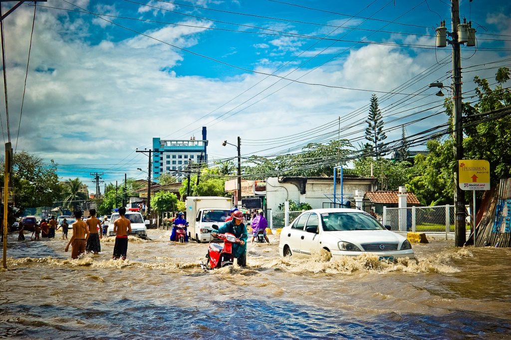 People wading through a flooded street. Prophecies concerning the last days warn of flooding and other natural disasters.